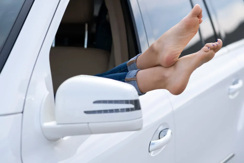 close-up-of-woman-driver-bare-feet-sticking-out-of-car