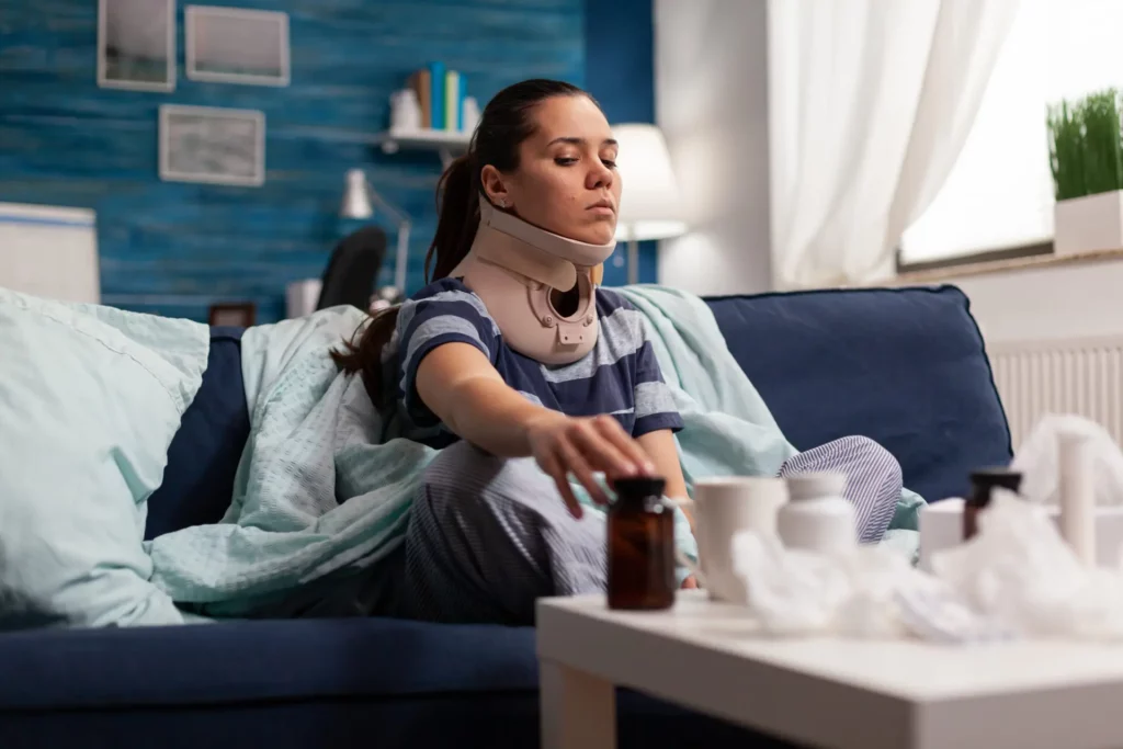 woman-in-neck-brace-suffering-from-pain-on-sofa